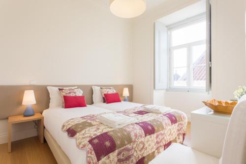 ein weißes Schlafzimmer mit einem Bett und einem Fenster in der Unterkunft FLH Baixa Modern Place in Lissabon