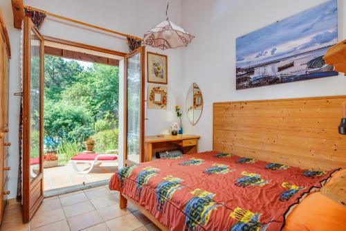 a bedroom with a bed and a sliding glass door at Maison entre Lac et Océan in Biscarrosse