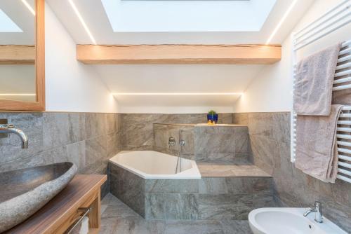 a bathroom with a tub and a sink at Guntschöllerhof Hochwart in Völs am Schlern
