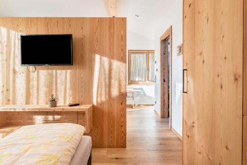 a bedroom with a bed and a tv on a wall at Guntschöllerhof Hochwart in Völs am Schlern
