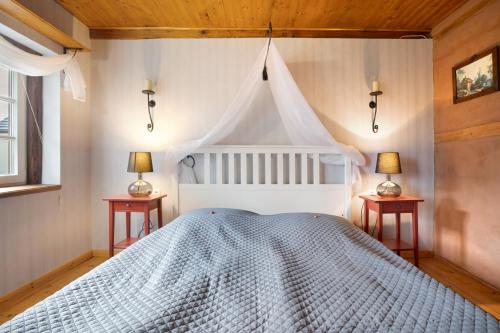 a bedroom with a white bed with two night stands at Ferienwohnung 'Zur Napoleonschanze' in Rathewalde