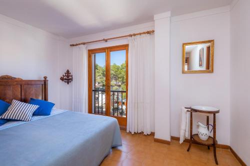 a bedroom with a blue bed and a window at Mastil in Cala Millor