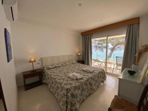 a bedroom with a bed and a view of the ocean at Catalina 2a tres dormitorios in Port de Pollensa