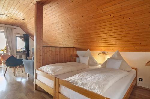 a bedroom with a bed with a wooden wall at Ferienwohnungen Kopp in Hagnau