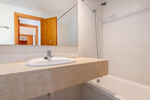 a bathroom with a sink and a tub and a mirror at Catalina 2a tres dormitorios in Port de Pollensa