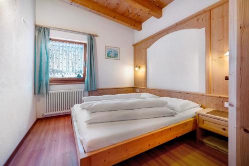 a large bed in a room with a window at Apartments Antersi Robbi in San Vigilio Di Marebbe