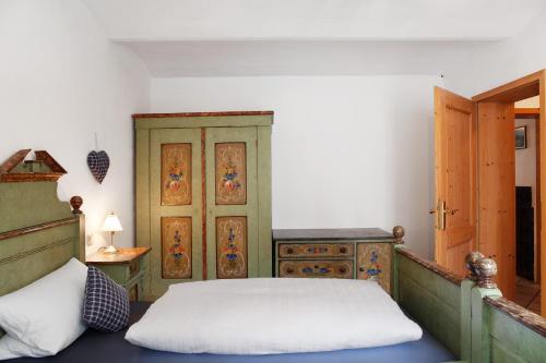a bedroom with a bed and a wooden cabinet at Zum Schnitzer Franzl in Garmisch-Partenkirchen