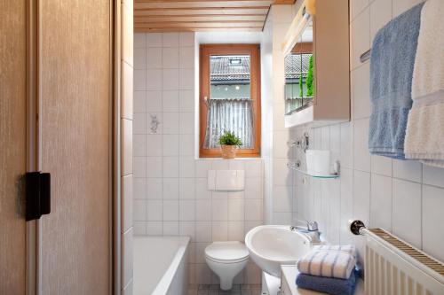 a white bathroom with a sink and a toilet at Zum Schnitzer Franzl in Garmisch-Partenkirchen