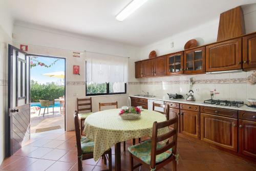 a kitchen with a table and a dining room at Casa da Alfarrobeira in Loulé