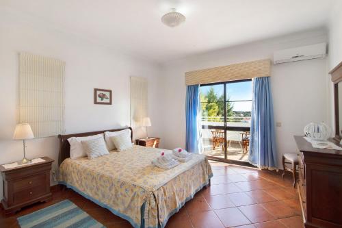 a bedroom with a bed and a window with a view at Casa da Alfarrobeira in Loulé