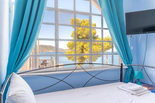 a bedroom with a large window and a bed at Wavedance Accommodation in Salamina