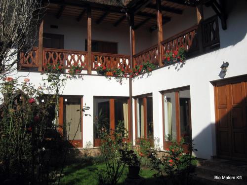 a house with a balcony with flowers on it at Júlia Vendégház in Tar