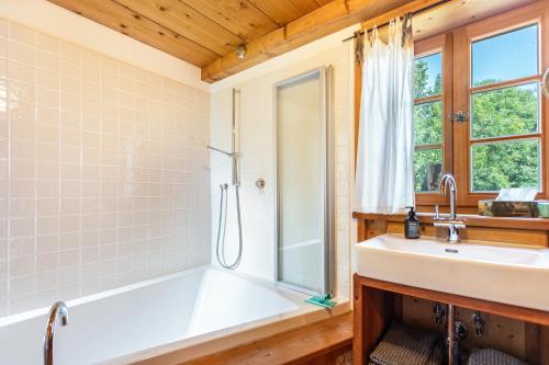 a bathroom with a white tub and a sink at Landhaus Gustl in Chieming
