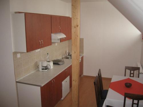 a small kitchen with a counter and a table at Júlia Vendégház in Tar