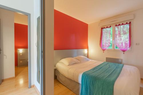 una camera da letto con pareti rosse e arancioni e un letto di La Rochelle a Saint-Simon-de-Bordes