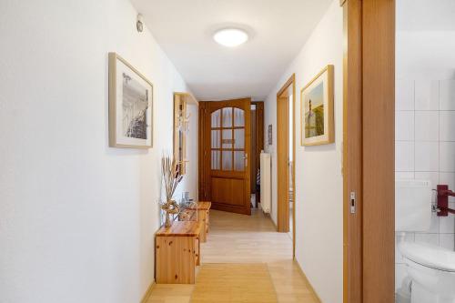 a hallway of a bathroom with a toilet and a sink at An der Silberfuchsbörse in Wurster Nordseeküste