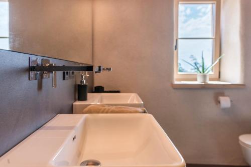 a bathroom with two sinks and a window at Egger an der Lahn - Apt Dolomiten in San Genesio Atesino