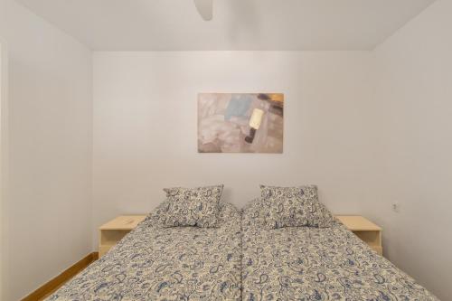a bed with two pillows and a picture on the wall at Villa Maria Maspalomas Gran Canaria in Maspalomas