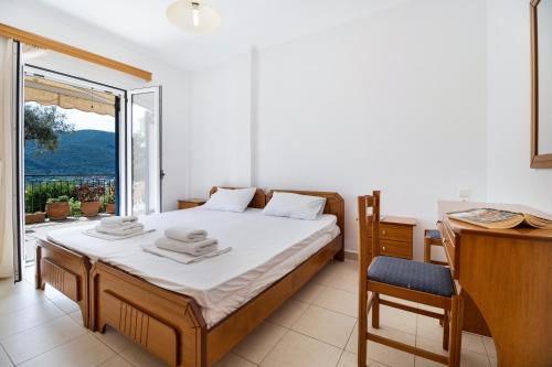 a bedroom with a bed and a desk and a window at Panorama apartment 1 in Póndi