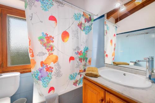 a bathroom with a sink and a shower curtain at Can noble den suau in Pollença