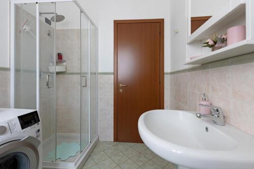 a bathroom with a sink and a washing machine at Residence Franciacorta in Rovato