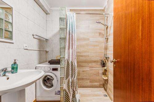 a bathroom with a washing machine and a sink at Casa da Travessa com 3 Quartos in Horta