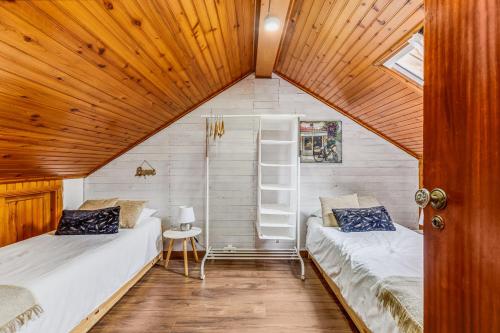 two beds in a small room with wooden ceilings at Casa da Travessa com 3 Quartos in Horta