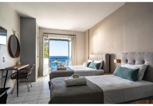 a bedroom with two beds and a view of the ocean at Sunset Triple 2 in Lefkada