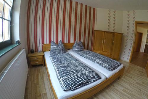 a bedroom with two beds with pillows at Ferienbauernhof - Ferienwohnung 5 in Grünow