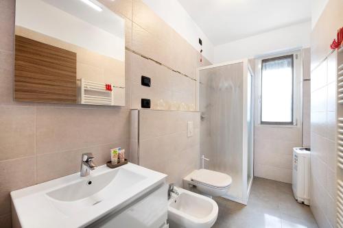 a white bathroom with a sink and a toilet at Appartamento 5 Il Tornante in Nesso