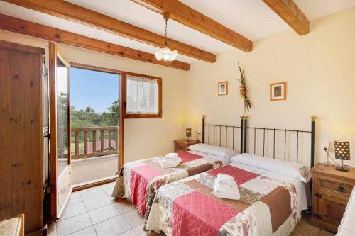 two beds in a room with a balcony at Les Cases in Sagás