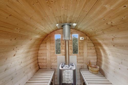 an inside view of a wooden cabin with benches and a stove at Les Cases in Sagás