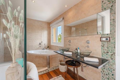 a bathroom with two sinks and a bath tub at Villa Bahia Azul in Llucmajor
