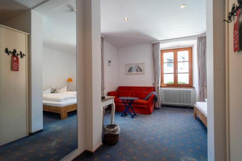 a hotel room with a red couch and a bed at Klostermeisterhaus in St. Blasien