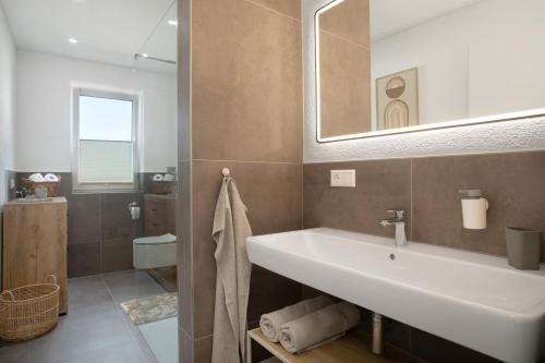 a bathroom with a sink and a mirror at Herzensprojekt in Pfullendorf