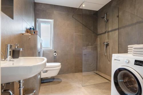a bathroom with a sink and a washing machine at Apartment mit Jacuzzi Enschede 10km in Gronau
