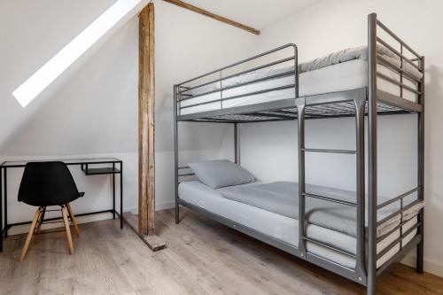 a bedroom with two bunk beds and a chair at Apartment mit Jacuzzi Enschede 10km in Gronau