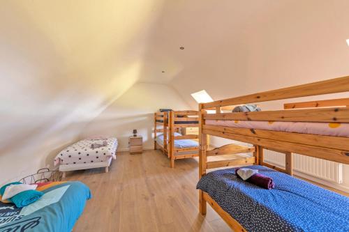 two bunk beds in a room with wooden floors at À la maison de Goulannou in Tréflez