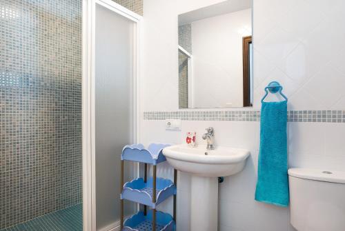 a white bathroom with a sink and a shower at Poniente in Roche