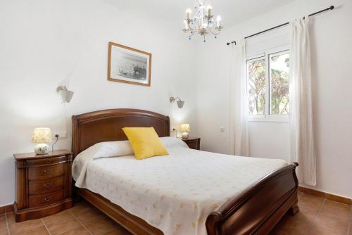 a bedroom with a bed with a yellow pillow on it at Poniente in Roche