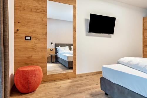 a bedroom with two beds and a mirror at Kamerloy Apartments B in Campitello di Fassa
