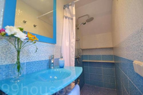 a blue bathroom with a sink and a shower at Benestar in El Toro