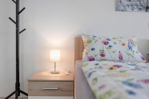 a bed with a pillow and a lamp on a night stand at Casa Karlsplatz in Freiamt