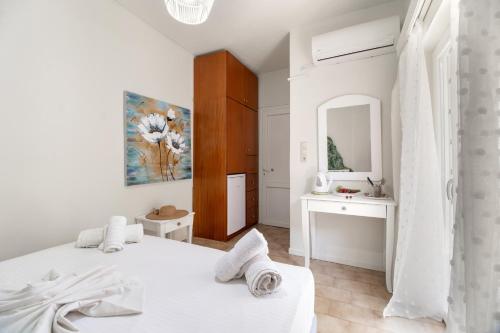a white bedroom with two beds and a mirror at M4 room in Nikiana