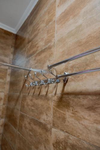 a shower head in a bathroom with a tile floor at Rhovee Homes in Moshi