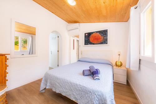 a bedroom with a bed and two windows at Can Juanito in Alcudia