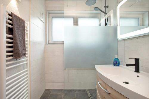 a white bathroom with a sink and a mirror at Ferienwohnung Schwenck in Kressbronn am Bodensee