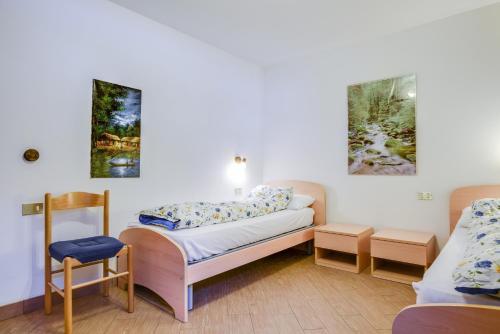 a room with a bed and two paintings on the wall at Villetta Crepaz in Canazei