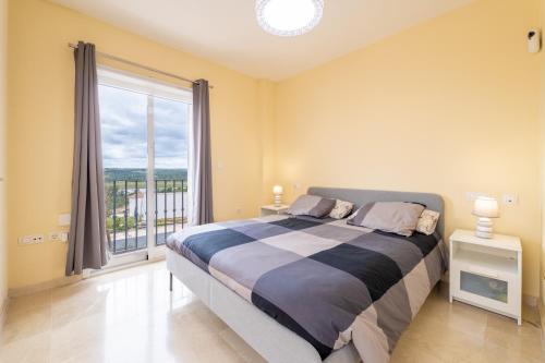a bedroom with a bed and a large window at Vista Hermosa in Ayamonte
