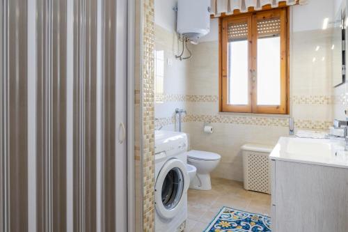 a bathroom with a washing machine and a washer at Villa Lindarelax in Santa Maria del Focallo